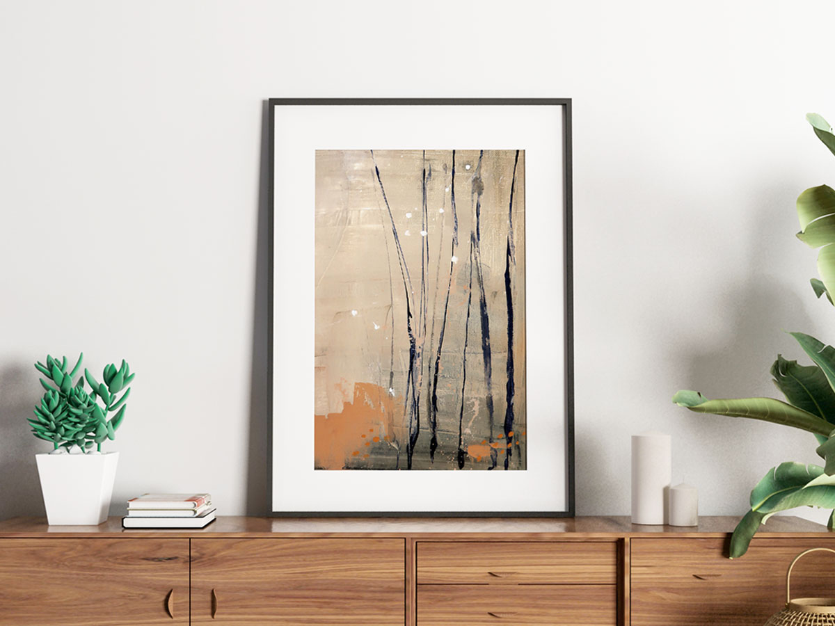 Abstract landscape painting of bare trees in colors of beige and rusty orange shown framed and sitting on a wood dresser