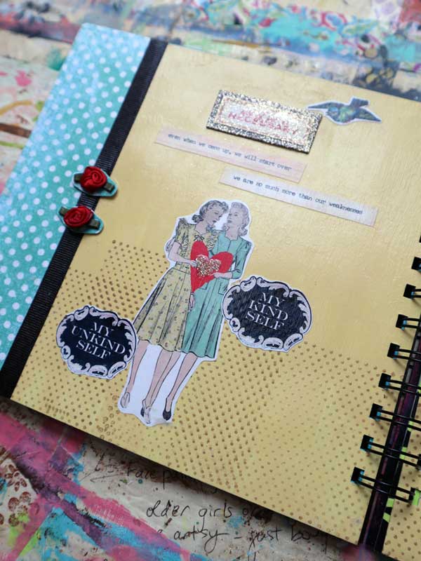 Page inside a handmade book showing vintage illustrations of women on a painted background with patterned paper and ribbon rose embellishments