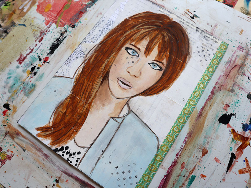 Painting of a girl with blue eyes and long red hair and bangs. She is wearing a light blue jacket and is painted on a background made of collage papers washed with white paint.