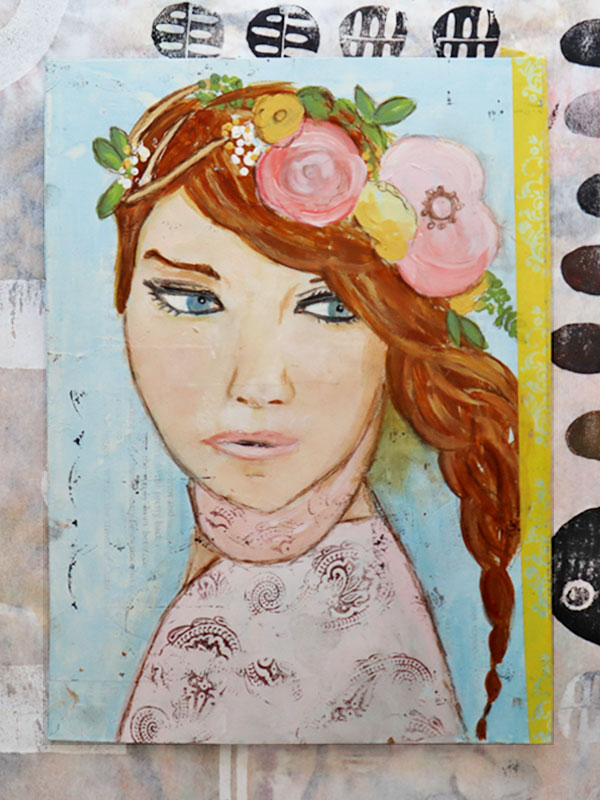 Painting of a girl with blue eyes and red hair in a side braid. She is looking to the side and has large pink and yellow flowers in her hair. She is wearing a light pink shirt stamped with a decorative pattern and is painted on a light blue background.