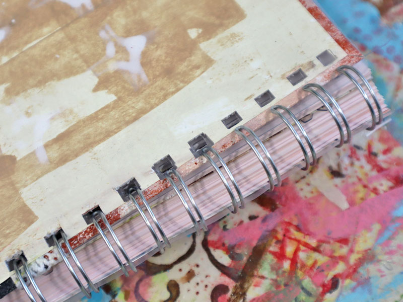 Close up of inserting new planner cover into spiral metal binding